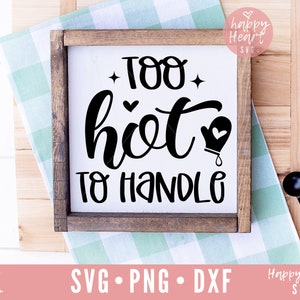 Peut inclure: Une pancarte en bois blanc avec du texte noir qui dit "Too hot to handle" avec un petit graphique de gant de cuisine. La pancarte est posée sur une surface à carreaux verts et blancs.