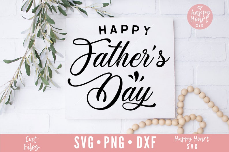 K&ouml;nnte beinhalten: Wei&szlig;er Hintergrund mit einem schwarzen Schild, auf dem in kursiver Schrift "Happy Father's Day" steht. Das Schild ist von Gr&uuml;npflanzen und Holzperlen umgeben.
