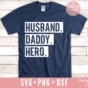 May include: A navy blue t-shirt with the text "HUSBAND. DADDY. HERO." in white.