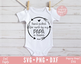May include: White baby onesie with black text that reads "hand picked for earth by my PAPA in heaven" inside a circle with arrows and dots.