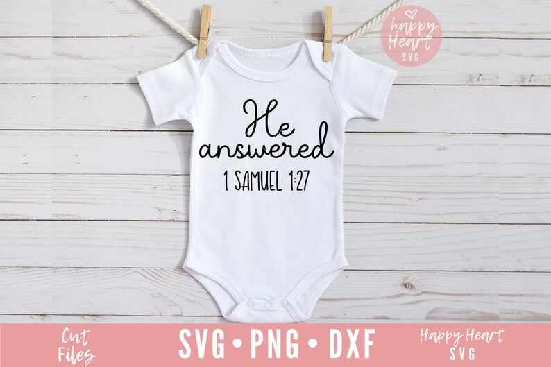 Op de afbeelding: Witte baby romper met zwarte tekst die "Hij antwoordde 1 Samuel 1:27" luidt.