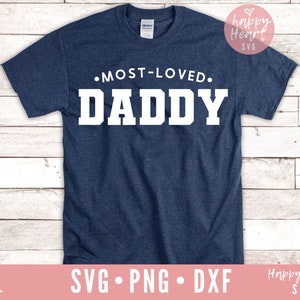 K&ouml;nnte beinhalten: Ein marineblaues T-Shirt mit dem Text "&bull;MOST-LOVED. DADDY" in Wei&szlig;.