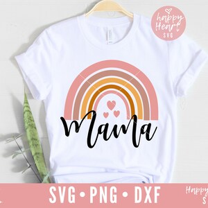 May include: A white t-shirt with a rainbow design and the word "Mama" in black script. There are three small pink hearts in the center of the rainbow.