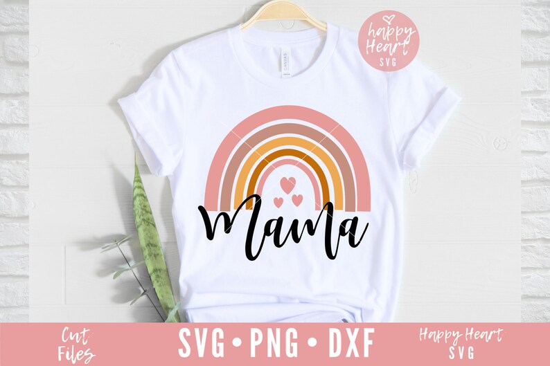 May include: A white t-shirt with a rainbow design and the word "Mama" in black script. There are three small pink hearts in the center of the rainbow.