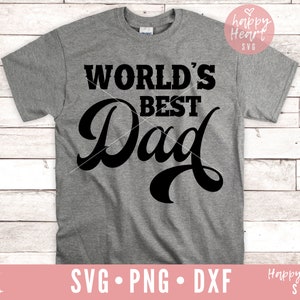 K&ouml;nnte beinhalten: Ein graues T-Shirt mit dem Text "WORLD'S BEST Dad" in schwarzen Buchstaben. Der Text ist in einer stilisierten Schriftart.