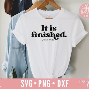 May include: White t-shirt with black text that reads "It is finished. JOHN 19:30". The text is in a retro font style.