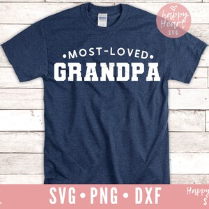 Op de afbeelding: Een marineblauw T-shirt met witte tekst die "MOST-LOVED. GRANDPA" luidt.
