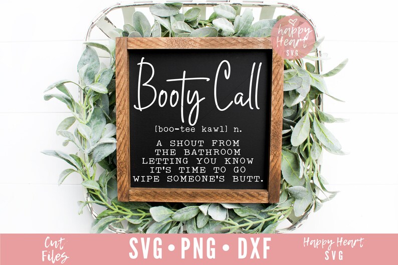 May include: A black framed sign with the text "Booty Call" and a definition of the term. The sign is sitting on a bed of green leaves.