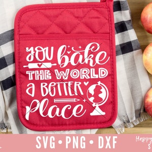 Könnte beinhalten: Ein roter, gesteppter Ofenhandschuh mit dem weißen Text "You bake the world a better place". Der Handschuh liegt neben einem schwarz-weiß karierten Tuch und drei Äpfeln in einem Holztablett. Das Bild enthält auch SVG-, PNG- und DXF-Schnittdateien.