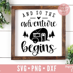 May include: A wooden sign with the text "And so the adventure begins" in black cursive font. A black silhouette of a camper van is in the center of the sign with two small pine trees on either side.