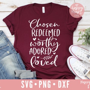 Op de afbeelding: Een maroon t-shirt met de tekst "Chosen Redeemed Worthy Adored Loved" in witte letters met kleine hartjes en een bladerenontwerp.