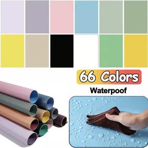May include: An image showcasing a range of coloured paper rolls and swatches. The image displays a variety of colours, including pink, blue, green, yellow, and black. Text in the image reads "66 Colors Waterpoof". A hand is wiping water off a blue surface.