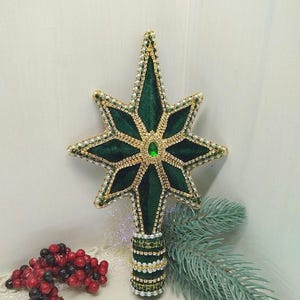 A green velvet Christmas tree topper in the shape of a hand-made star, decorated with beads and rhinestones. A Christmas tree ornament.