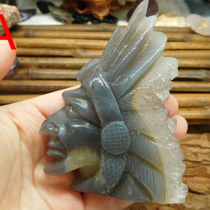 Puede incluir: Una escultura tallada en piedra de &aacute;gata gris de un jefe nativo americano con tocado. La piedra tiene una formaci&oacute;n de cristal natural en el lateral.
