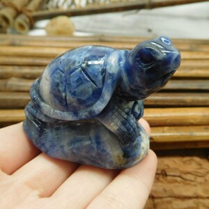May include: A blue and white carved turtle figurine made of sodalite.