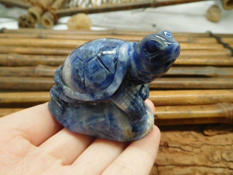 May include: A blue and white carved turtle figurine made of sodalite.