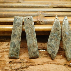 Puede incluir: Cuatro colgantes de piedra preciosa, dos rectangulares y dos en forma de lágrima, de color verde y marrón moteado.