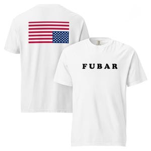 Puede incluir: Camisetas blancas. Una tiene la palabra "FUBAR" impresa en negro en la parte delantera. La otra tiene un diseño de la bandera estadounidense en la espalda. Las camisetas son de manga corta y están hechas de un material suave.