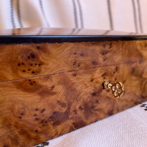 close up shot on lock and key of thuya wooden jewelry box - showcasing natural wood burl grains