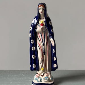Hand-painted ceramic Virgin Mary figurine with Sacred Heart, blue cloak with white dots, standing on cloud base, folk style religious statue
