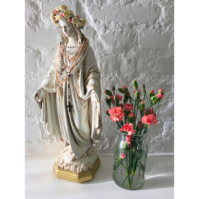 Estatua de la Virgen María con corona floral y rosario. imagen 4