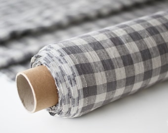 May include: A roll of gray and white gingham fabric. The fabric is woven with a checkered pattern and is rolled up on a cardboard tube.
