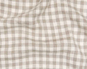 May include: A close-up of a beige and white gingham fabric with a subtle texture. The fabric is woven with a checkered pattern and has a soft, natural feel.