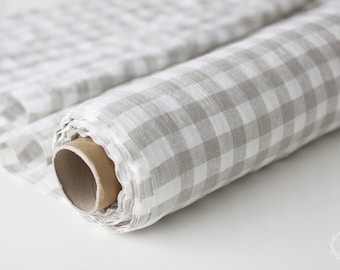May include: A roll of white and beige gingham fabric. The fabric is rolled up on a cardboard tube.