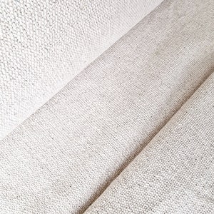 Pu&ograve; includere: Primo piano di un tessuto bianco sporco strutturato con trama visibile. Il tessuto &egrave; piegato, creando linee diagonali e ombre. Il materiale sembra essere una fibra naturale, forse lino o cotone, adatto per tappezzeria o abbigliamento.