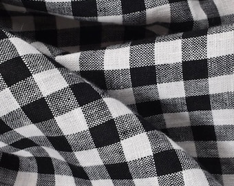 May include: Black and white gingham fabric with a woven texture. The fabric is folded and shows the pattern.