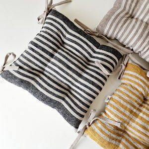 Puede incluir: Tres cojines de silla a rayas con lazos. Los cojines est&aacute;n hechos de tela de lino y tienen un dise&ntilde;o acolchado. Los cojines son de rayas negras y blancas, beige y blancas, y amarillas y blancas.