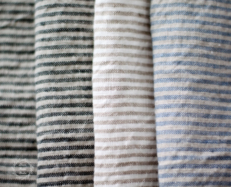 Pu&ograve; includere: Primo piano di tre campioni di tessuto con strisce di colori diversi. I campioni sono una striscia grigio scuro e bianca, una striscia marrone chiaro e bianca e una striscia blu chiaro e bianca.