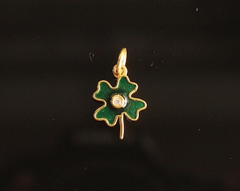 May include: A gold four-leaf clover charm with a green enamel finish and a clear rhinestone in the center.