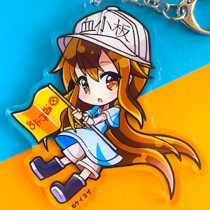 Könnte beinhalten: Ein durchsichtiger Acryl-Schlüsselanhänger mit einer Cartoon-Anime-Figur mit langen braunen Haaren, die einen weißen Hut mit dem Text "血小板" in Schwarz trägt. Die Figur hält eine gelbe Flagge mit dem Text "歩行者通路" in Rot und Schwarz. Der Schlüsselanhänger hat eine silberne Kette.