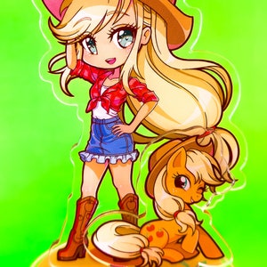 May include: A clear acrylic stand with a cartoon image of a female character wearing a red shirt, blue jeans, and a cowboy hat. The character is standing with her right hand on her hip. A smaller cartoon image of a pony is sitting at her feet. The stand has a yellow base with red apples.