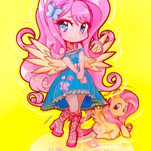 May include: A pink and yellow anime-style character with wings and cat ears stands on a base with butterflies. The character is wearing a blue dress with a white collar and white sleeves. The character has pink hair and blue eyes. The character is holding a small pink and yellow pony with wings.