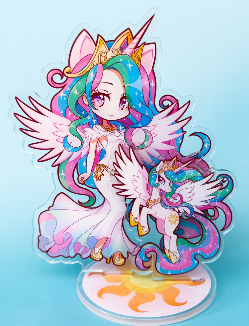 Puede incluir: Un soporte de acr&iacute;lico transparente con una ilustraci&oacute;n de estilo chibi de la Princesa Celestia de My Little Pony: La Magia de la Amistad. Celestia est&aacute; representada como un unicornio alado con una corona dorada y una melena y cola fluidas con rayas rosas, azules y amarillas. Ella sostiene una versi&oacute;n m&aacute;s peque&ntilde;a de s&iacute; misma en su pezu&ntilde;a.
