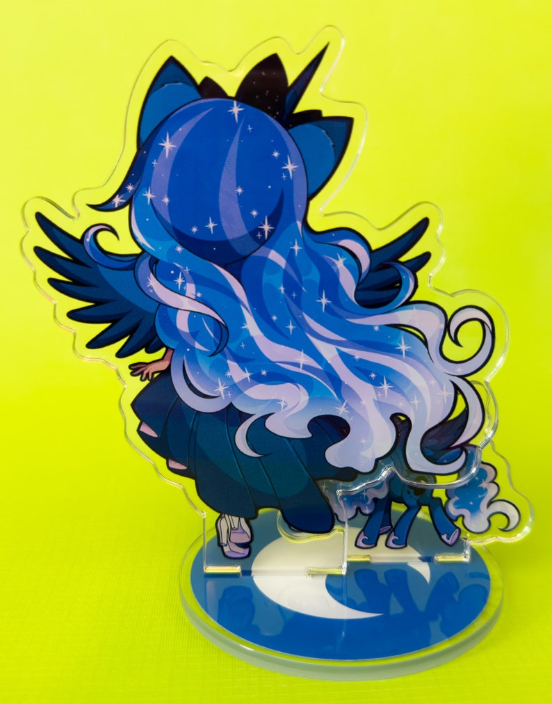 Puede incluir: Un personaje de estilo anime azul y morado con alas y una base de media luna. El personaje tiene el pelo largo y fluido con estrellas incrustadas. El personaje est&aacute; de pie sobre una base de media luna con un fondo azul.