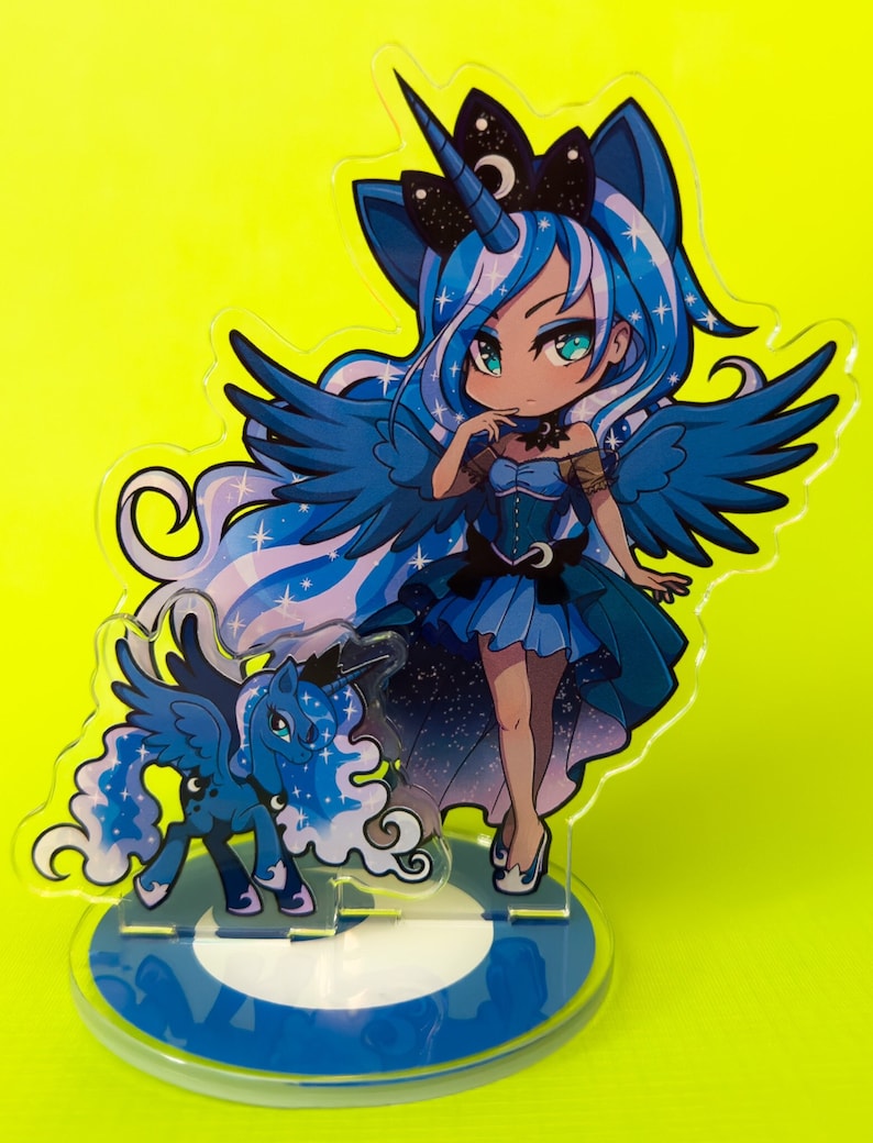 Puede incluir: Una figura de estilo anime azul y blanco de un unicornio alado con una luna creciente en la frente. La figura est&aacute; de pie sobre una base circular azul y blanca.