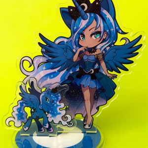 Puede incluir: Un personaje de estilo anime azul y blanco con alas y un cuerno de unicornio. El personaje lleva un vestido azul y tiene una corona en la cabeza. El personaje est&aacute; de pie sobre una base azul y blanca.