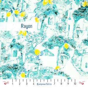 Può includere: Tessuto bianco con una stampa turchese e blu di un villaggio europeo con alberi di limone. Il tessuto è etichettato "Rayon".