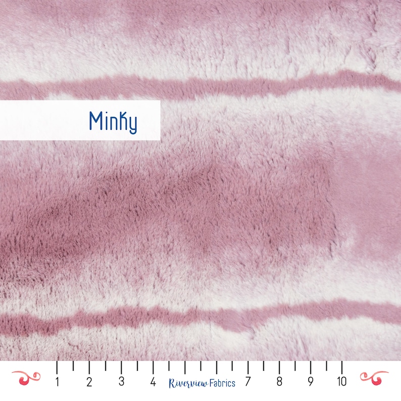 May include: A close-up of a soft, pink and white minky fabric with a striped pattern. The fabric is textured and fuzzy, and the stripes are subtle and faded. The fabric is labeled "Minky".