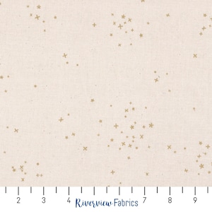 Puede incluir: Una tela beige con un patrón disperso de estrellas doradas y signos más. La tela se mide en pulgadas.