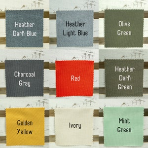 K&ouml;nnte beinhalten: Neun Stoffmuster in verschiedenen Farben und Texturen, darunter dunkelblauer Melange, hellblauer Melange, Olivgr&uuml;n, Anthrazitgrau, Rot, dunkelgr&uuml;ner Melange, Goldgelb, Elfenbein und Mintgr&uuml;n.