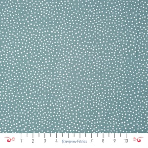 Pode incluir: Um tecido azul turquesa com um padrão de bolinhas brancas. O tecido é mostrado com uma régua para escala.