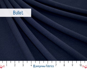 May include: A close-up of a dark blue fabric with a textured surface. The fabric is folded and draped, showing its texture and drape. A ruler is visible at the bottom of the image, with markings from 1 to 10 inches. The text "Bullet" is visible at the top of the image.