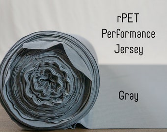 Puede incluir: Un rollo de tejido de punto Performance rPET gris.