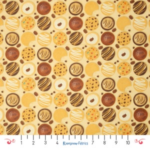 Pode incluir: Um tecido amarelo com um padrão repetitivo de vários biscoitos. Os biscoitos são de diferentes formas e cores, incluindo chocolate, baunilha e gengibre.