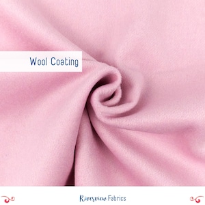 May include: A close-up of a soft, pink wool coating fabric. The fabric is folded and draped, showcasing its texture and drape.