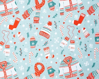May include: A blue fabric with a repeating pattern of winter-themed illustrations. The pattern includes red and white mittens, scarves, hats, sweaters, and candy canes. The background is a light blue color with white snowflakes.